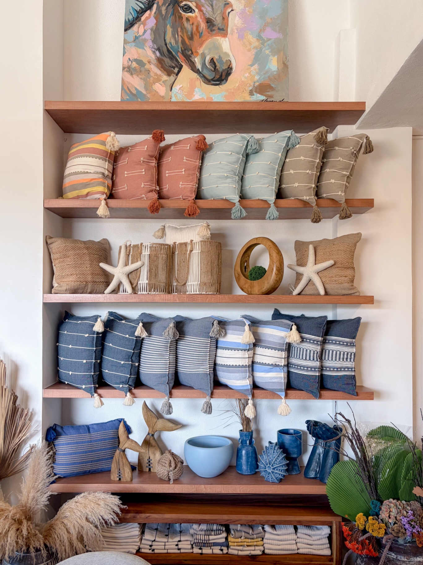 Repisas de madera con cojines texturizados y cerámica en el showroom Mezquite