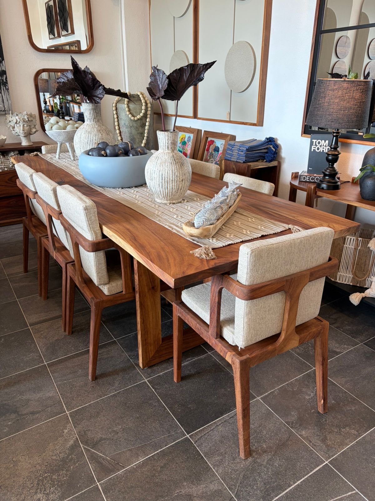 Comedor de parota con sillas de madera y textiles artesanales en el showroom Mezquite